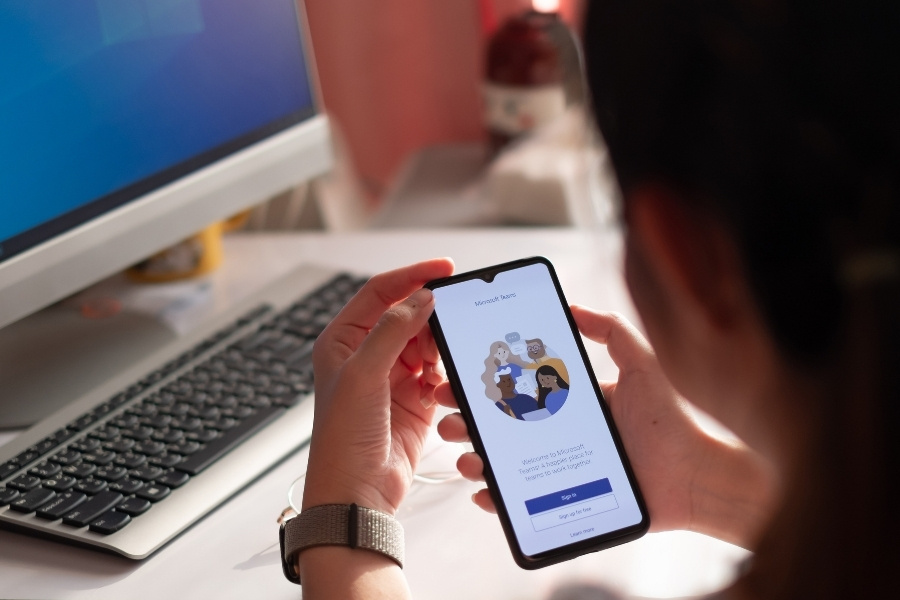 Working from Home Employee Is Downloading the Microsoft Teams Social Platform,